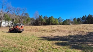 Meeks Land Management compact track loader on a cleared North Alabama property in winter